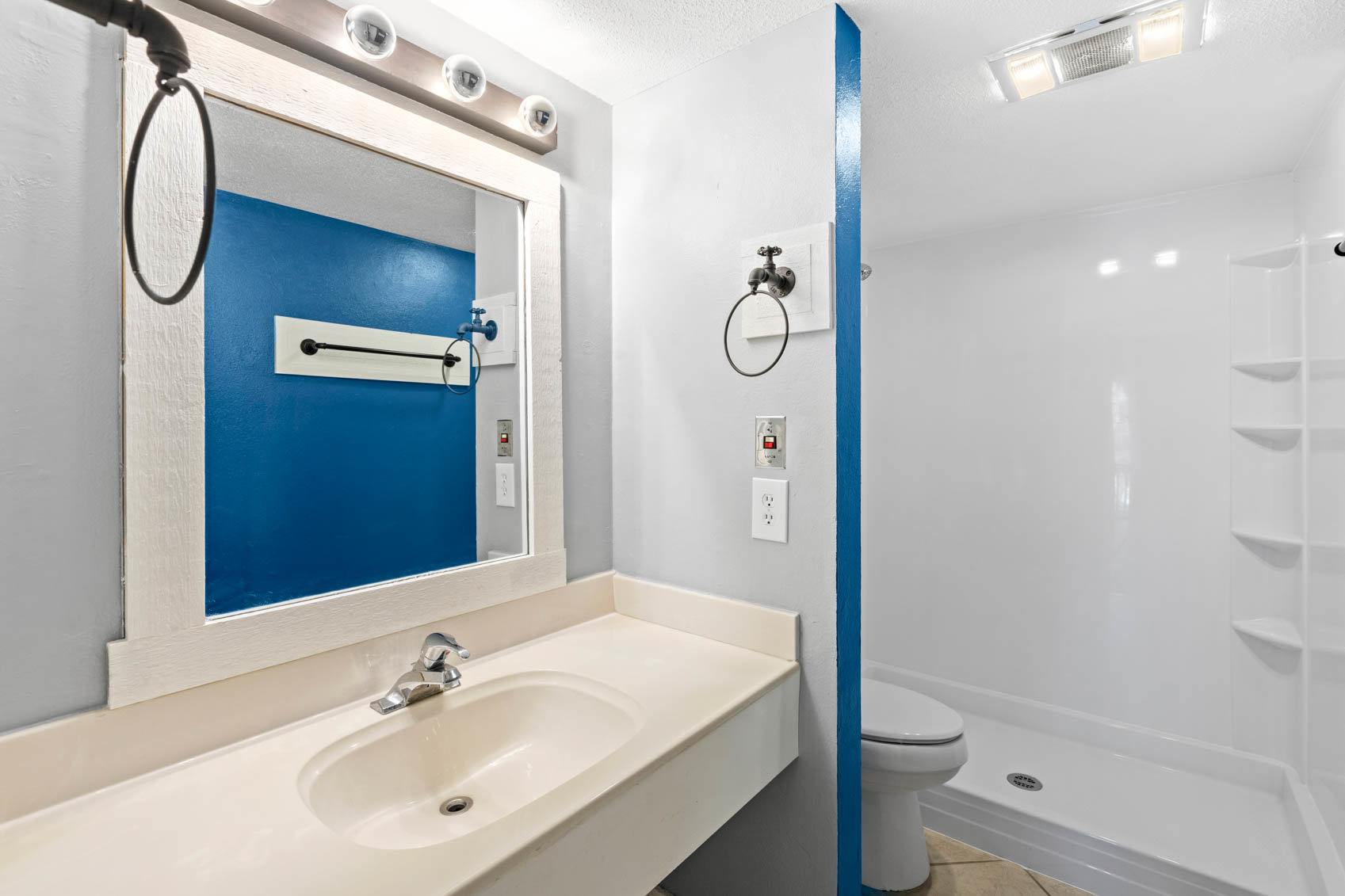 bathroom with white counters and blue wall